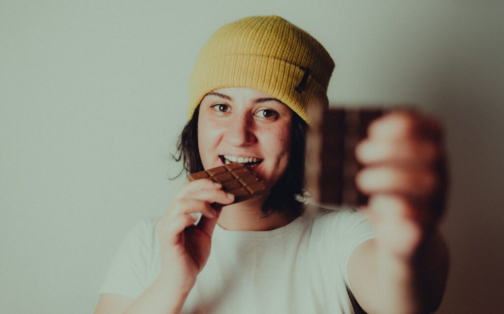 nainen esittelee vegaanisia suklaapatukoita
